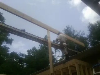 Carpenter setting a ridge beam over a new addition frame — Ice Dam Removal by Roofing Brothers in Montgomeryville
