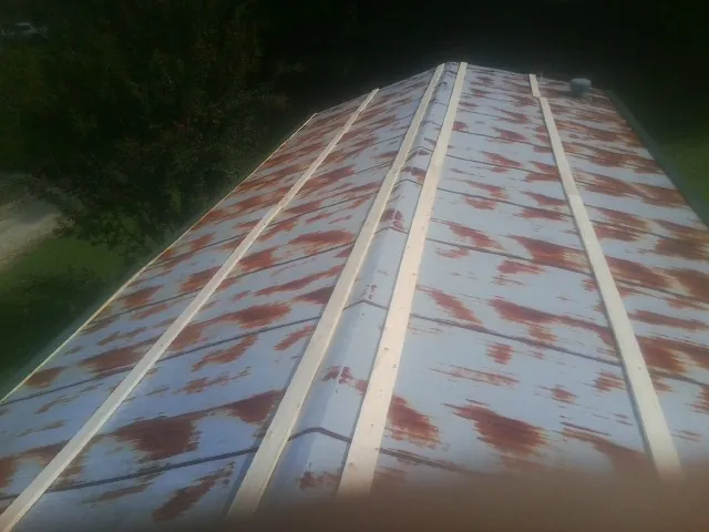 Rusted metal roof panels with new wood purlins before replacement — Storm Damage Roof Repair in Montgomeryville by Roofing Brothers