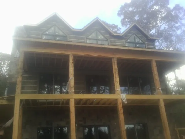 Dormers and porch framing on a large log home under construction — Roof Coating work by our crew in Montgomeryville