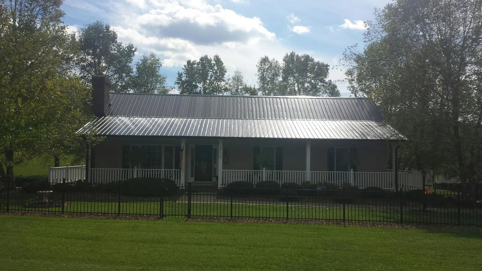 Gray metal roof on a brick ranch with a full width front porch — Gutter Guard Installation work by our crew in Montgomeryville